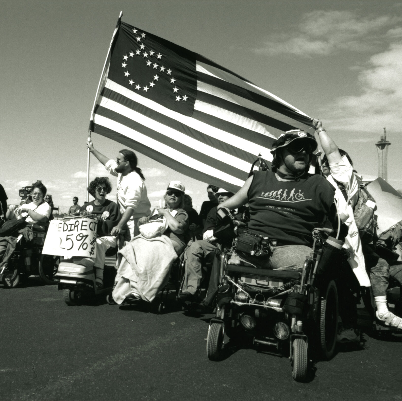 Image by Tom Olin that shows Vegas Advocacy walk and ride for disability rights with disability flag