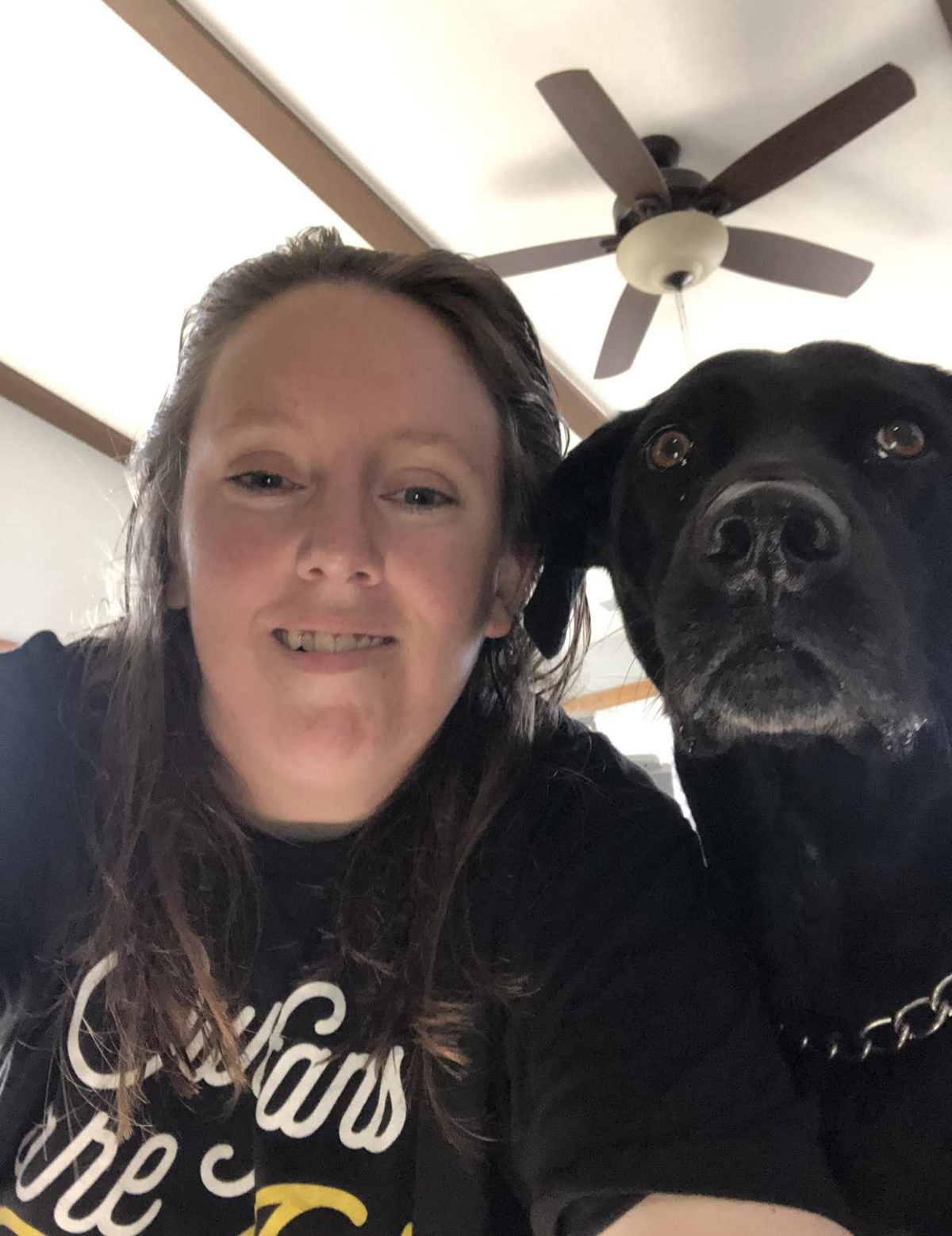 Jennifer, white young lady staring at camera with her dog. She is smiling at camera.