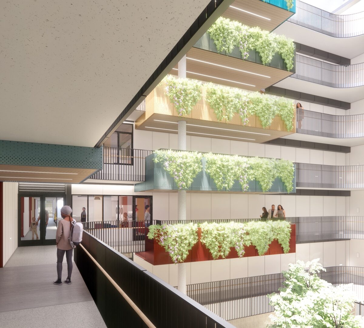 The courtyard of The Kelsey Civic Center, with different colored balconies on each of the floors. Plants hang down from the balconies.