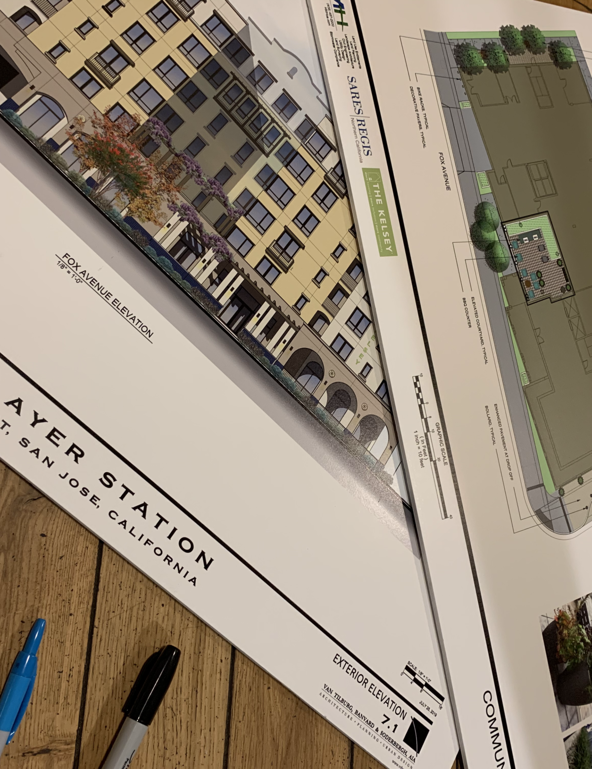 Architectural drawings of The Kelsey Ayer Station atop a table with markers on it.