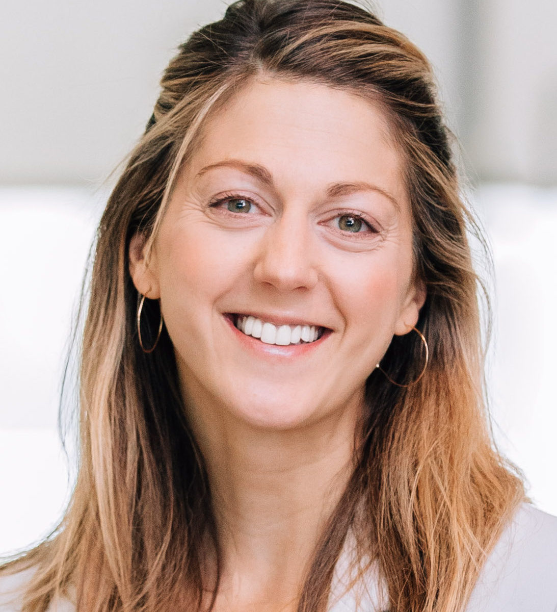 White woman smiling at camera with light long brown hair