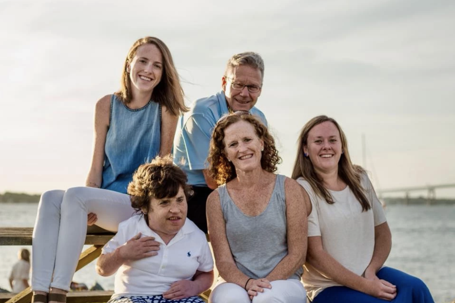 Kelsey Flynn O'Connor is pictured with her parents and two sisters. There is water in the background.