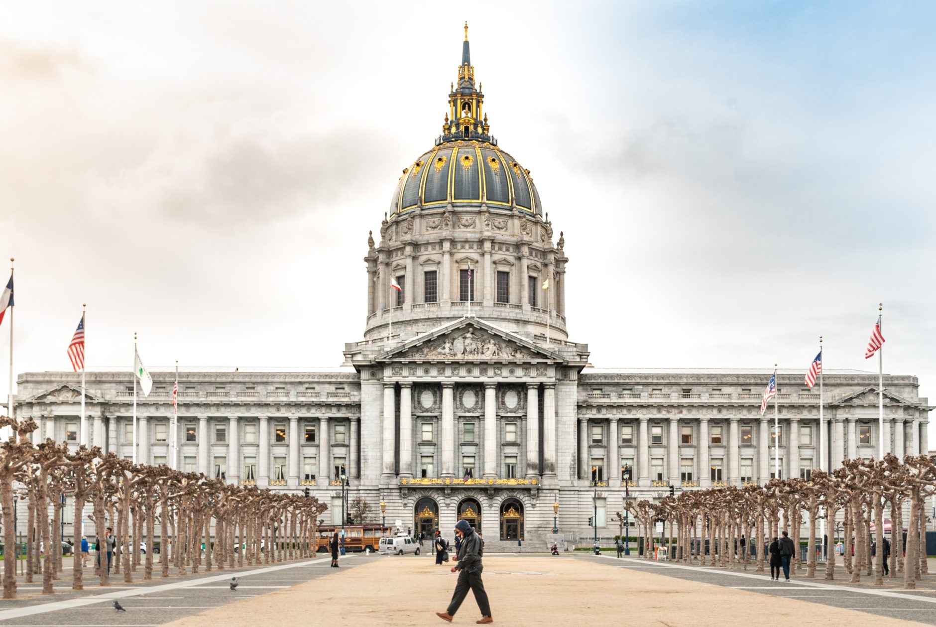 Image of San Francisco City hall in color with one person walking by.