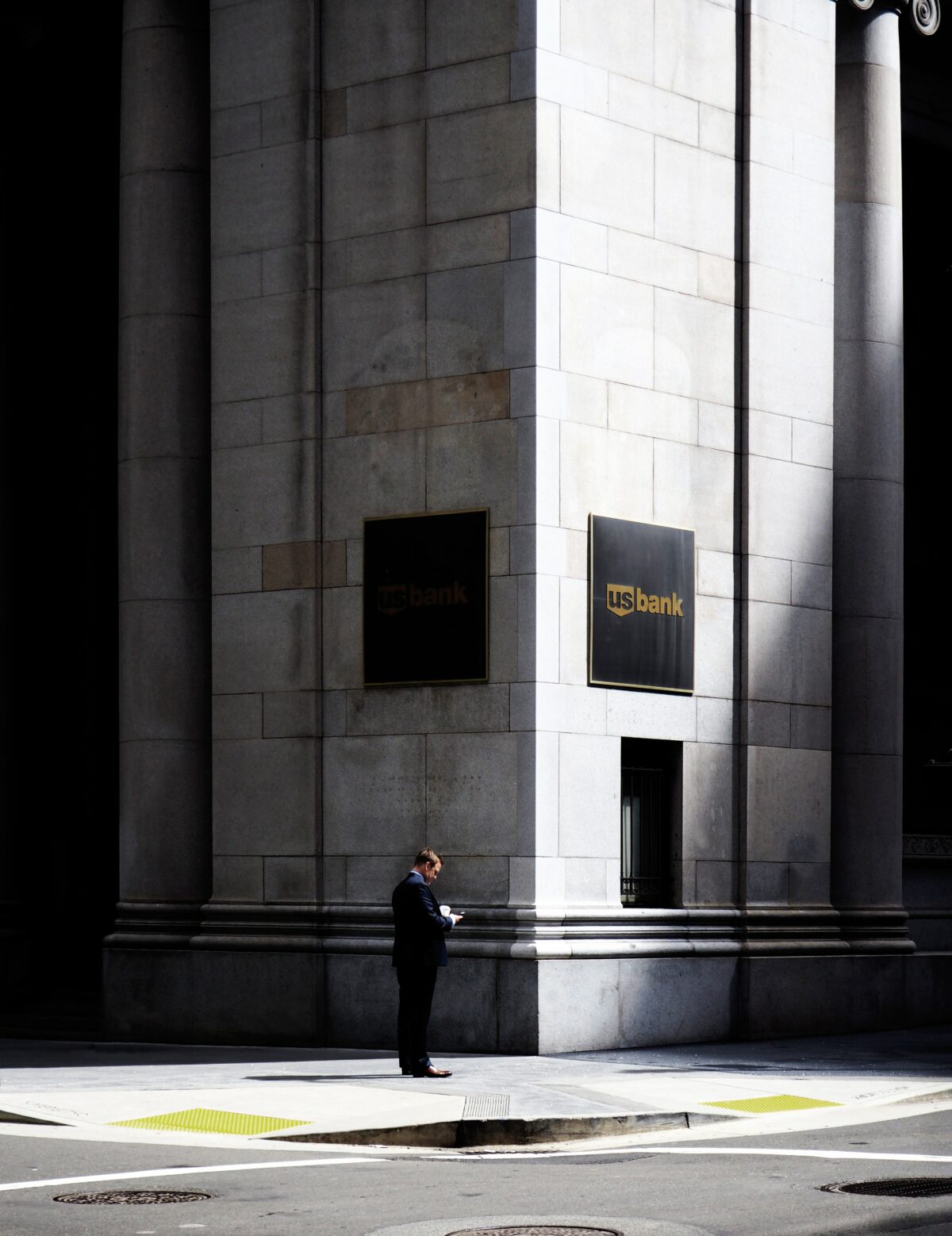 A man stands on the corner of a U.S. Bank Building.