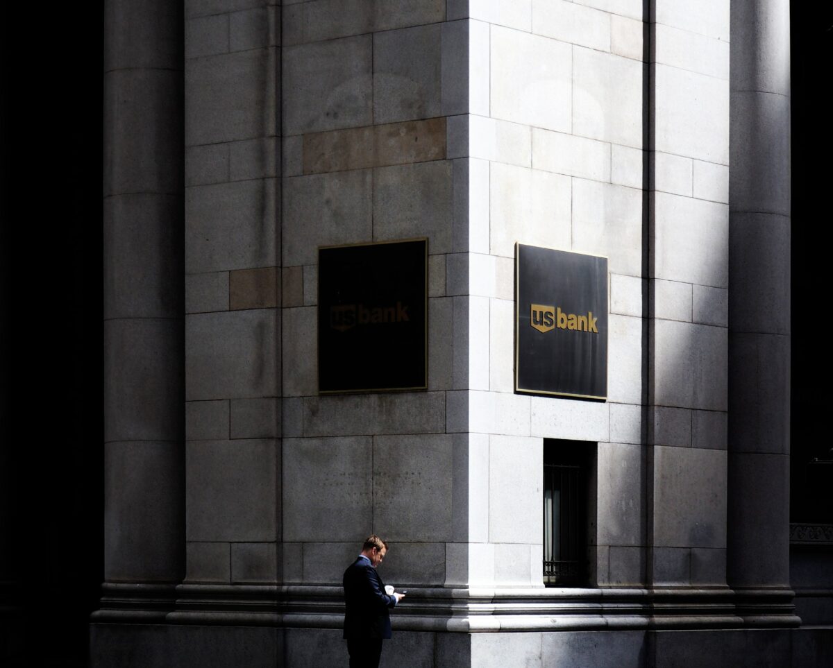 A man stands on the corner of a U.S. Bank Building.