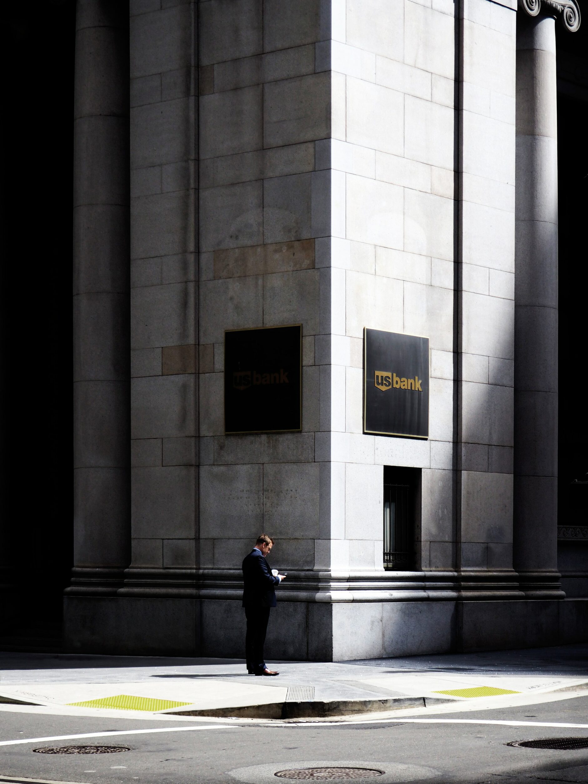 A man stands on the corner of a U.S. Bank Building.