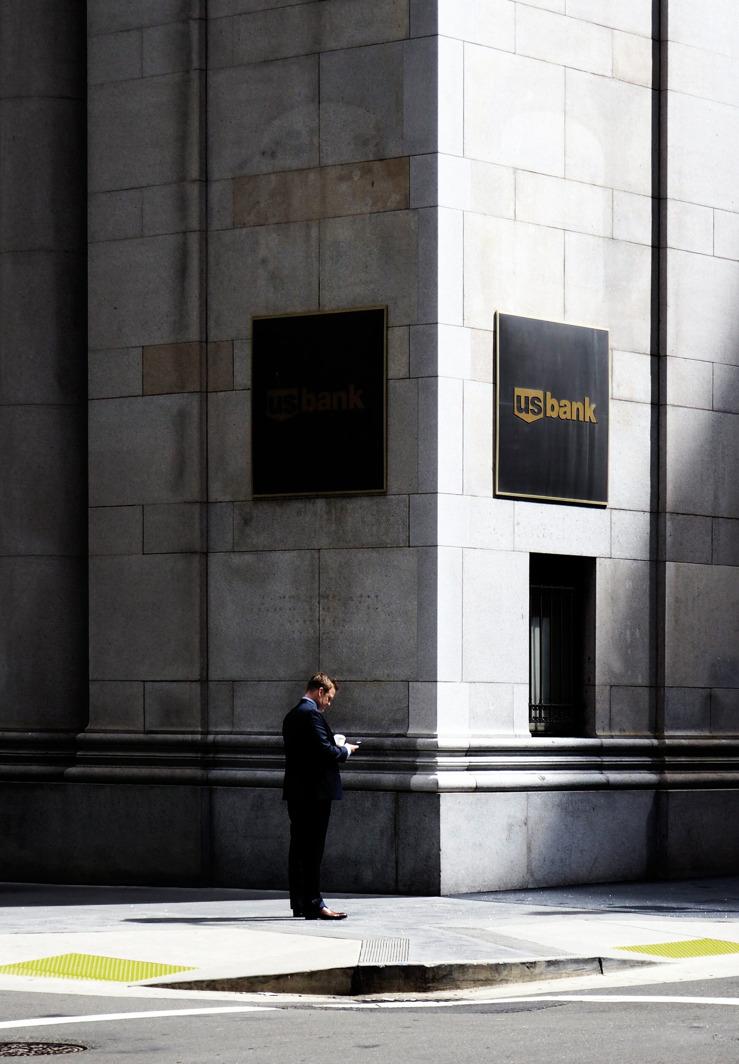 A man stands on the corner of a U.S. Bank Building.