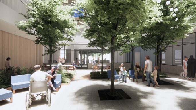 The Interior of the courtyard of The Kelsey Civic Center. Trees are visible in the courtyard. People can be seen sitting, standing and walking.