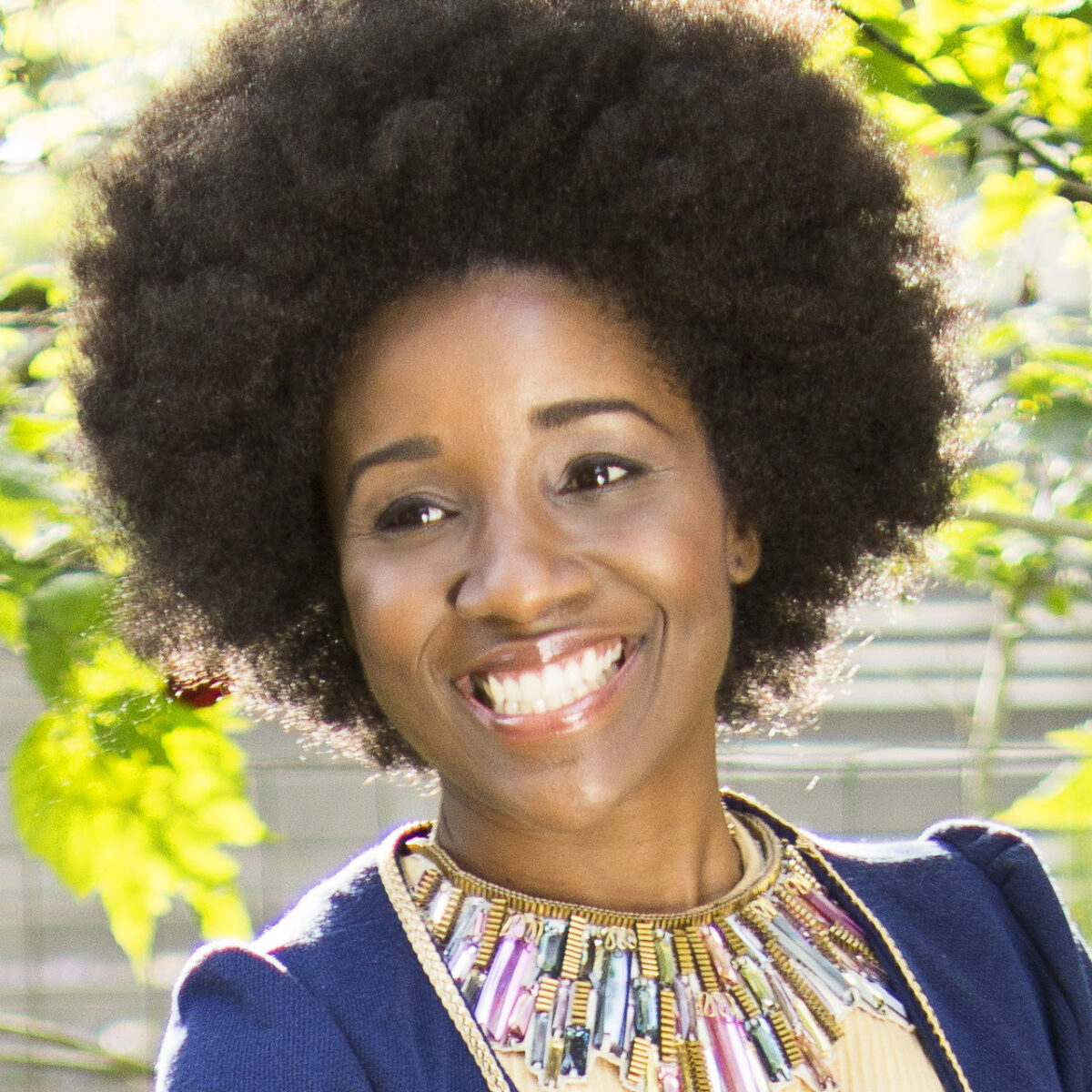 Fatimah Aure, a dark-skinned woman with dark hair wearing a shirt with a decorative neckline is pictured.