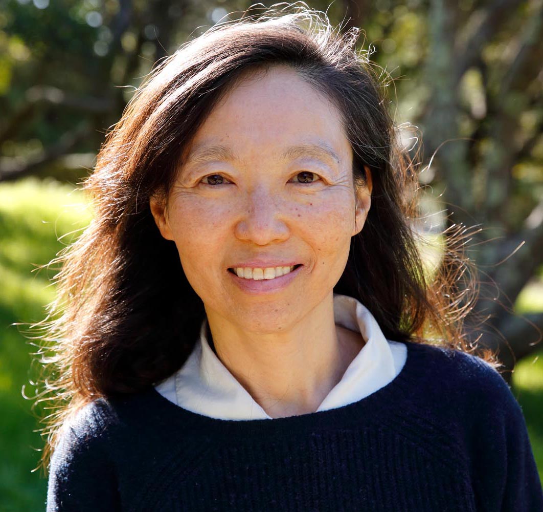 Chan U Lee, a woman of East Asian descent, is pictured. She has long dark hair, and is wearing a blue sweater with a white shirt underneath it.