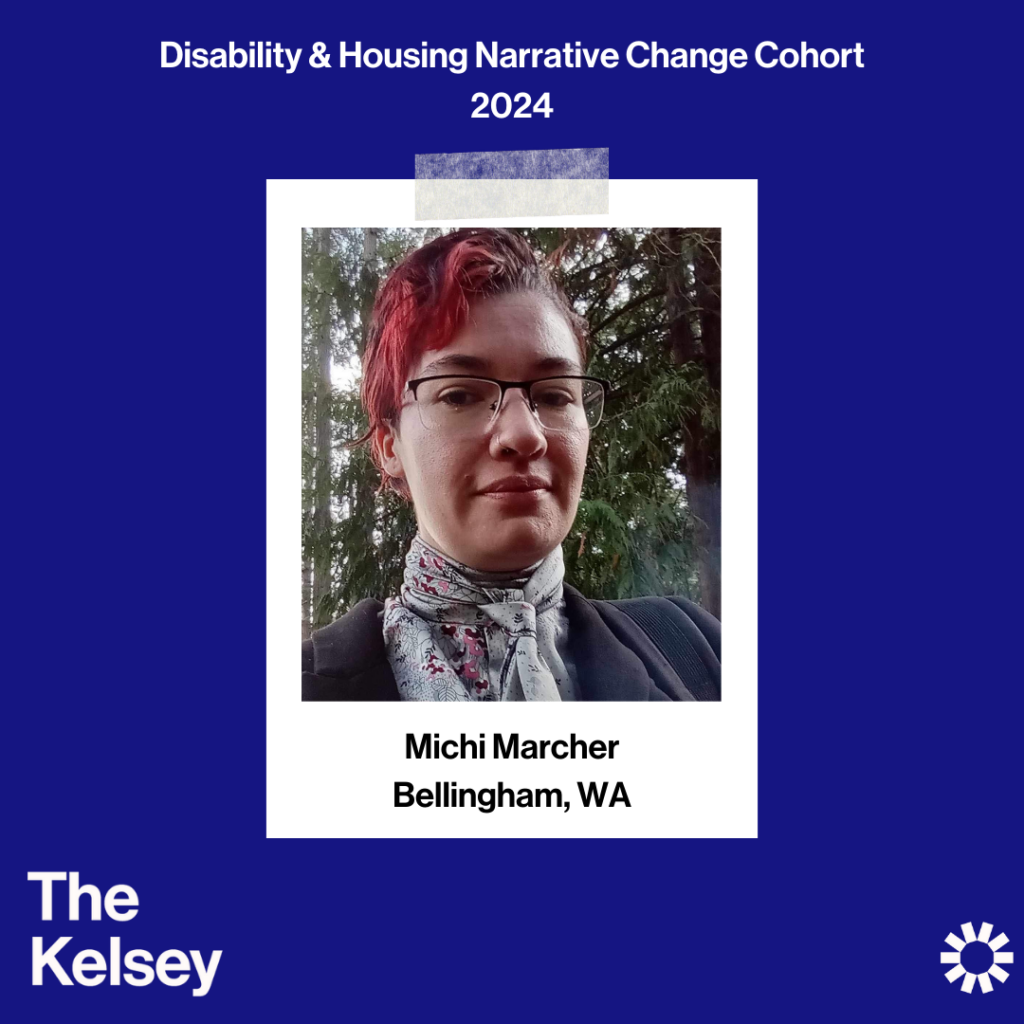 Text on a blue background reads “Disability & Housing Narrative Change Cohort 2024.” Michi Marcher is pictured on a polaroid-like image. They have short red hair and are wearing glasses and a patterned top. Text in the lower left corner of the image reads “The Kelsey.” The Kelsey logo is visible in the lower right-hand corner.