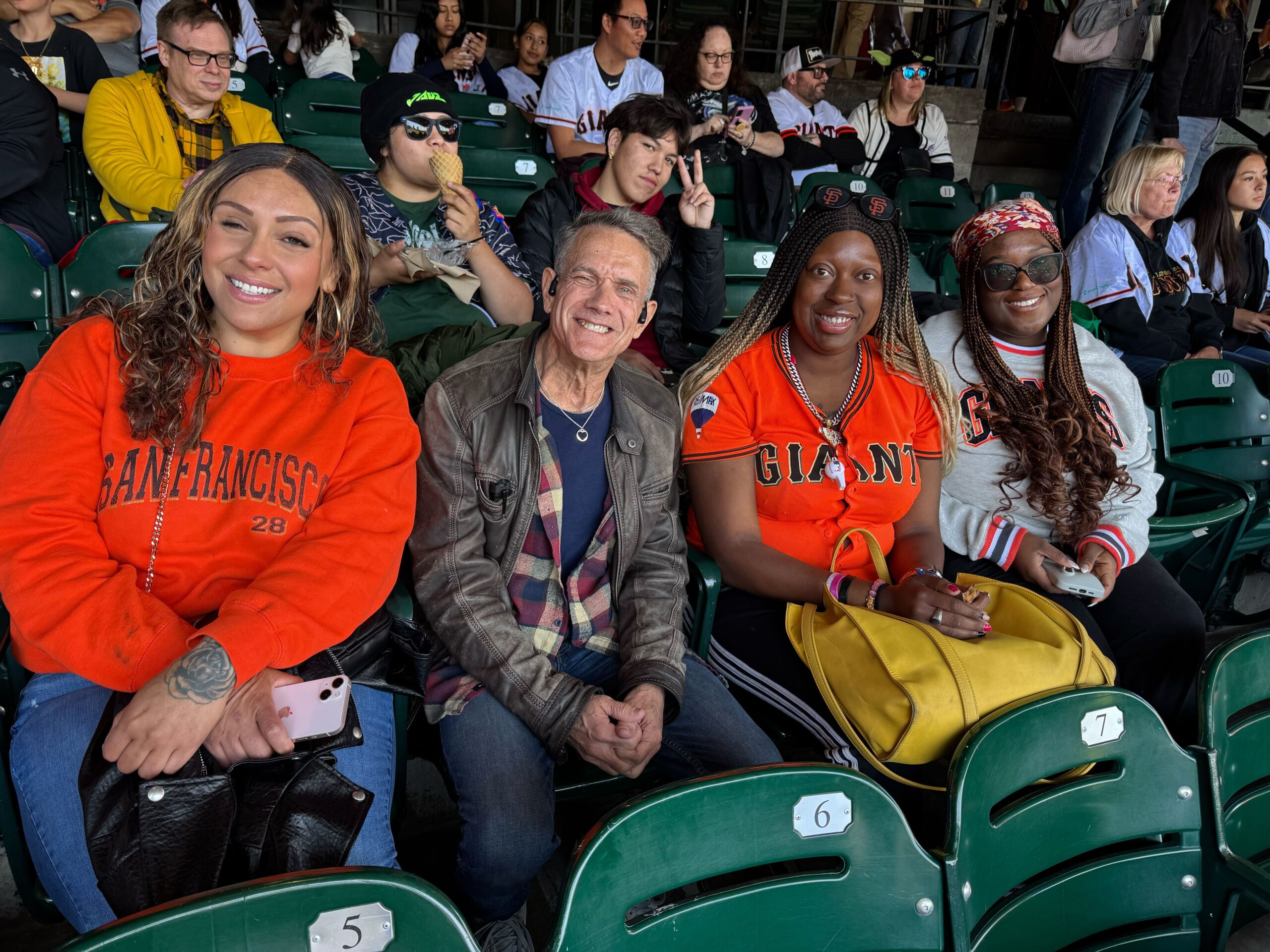 Members of The Kelsey’s Inclusion Concierge team and residents smile and pose in the stands of the Giants game.