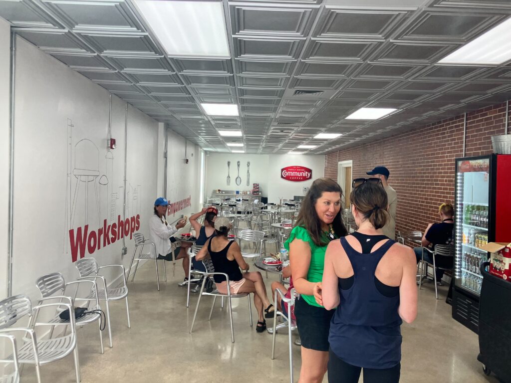 The Kelsey Avondale site clean-up volunteers sit and stand in the lunchroom at Workshops Empowerment.
