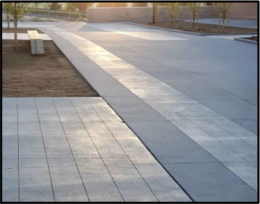 Different kinds of paving on a walkway outside an apartment building.