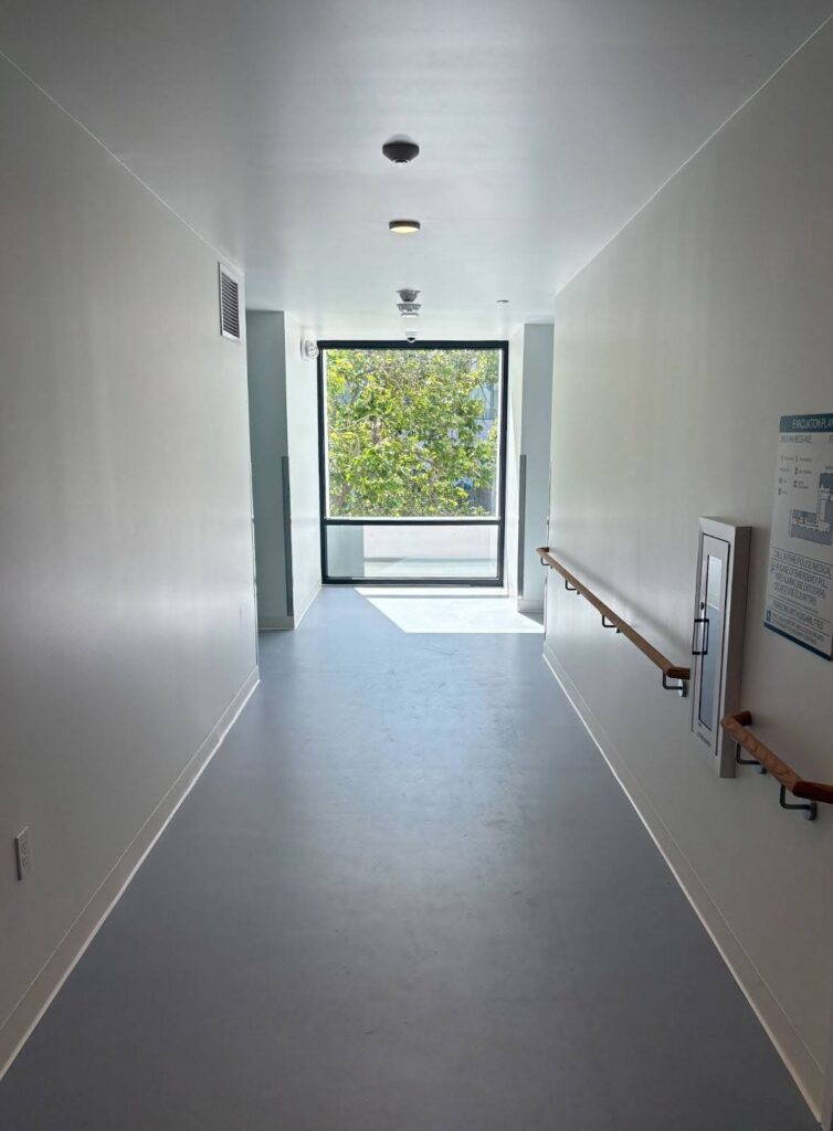 A large window looking out to greenery at the end of a hallway at The Kelsey Civic Center. 