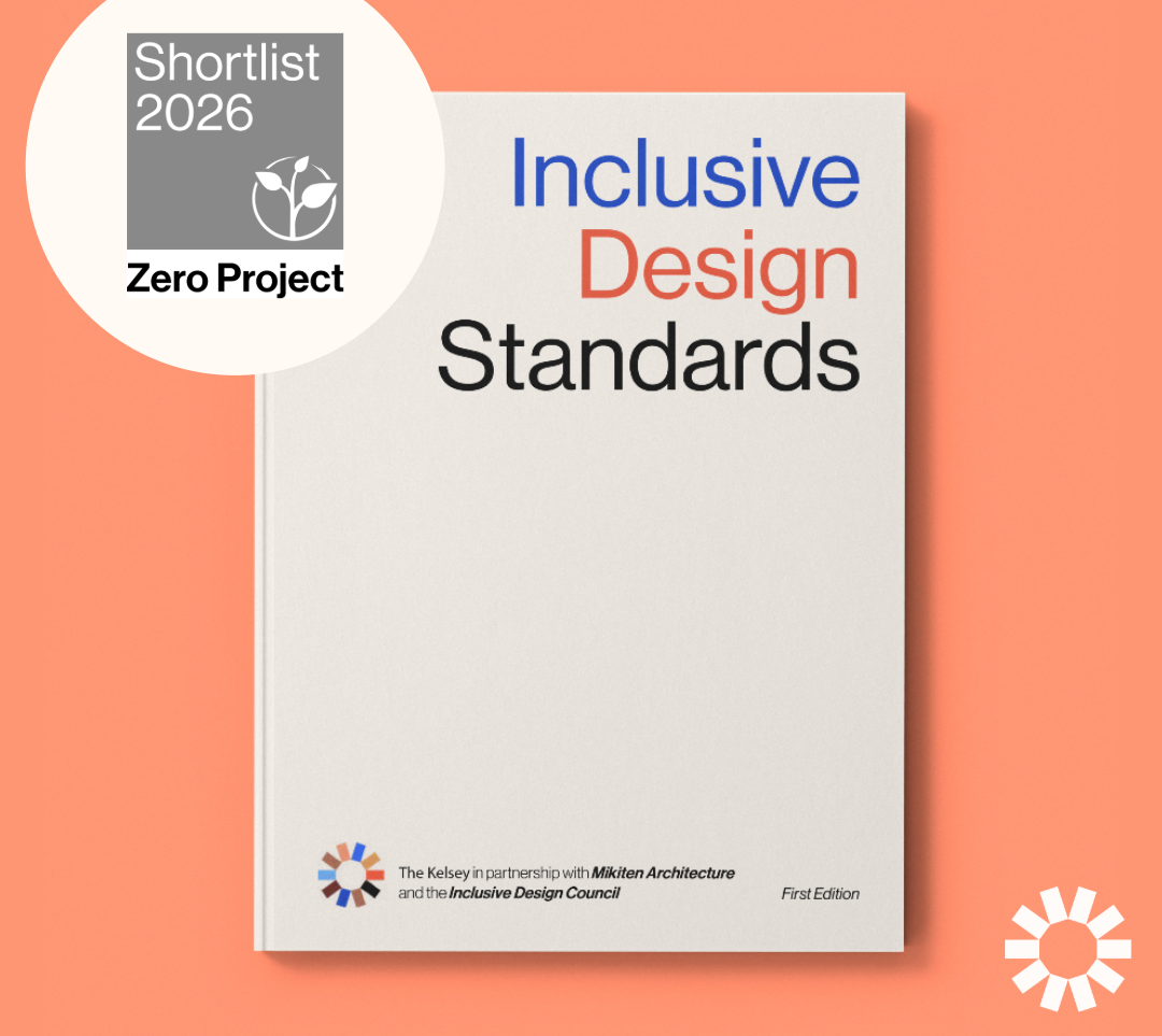 A graphic announcing the shortlisting of the Inclusive Design Standards for the Zero Project Awards 2026. On the left, a white circular badge with a gray square in the center reads: “Shortlist 2026, Zero Project” with the Zero Project logo. On the right, a white book cover is shown against a coral background. The book title reads “Inclusive Design Standards” in blue, coral, and black text. At the bottom, logos and text note that the publication is by The Kelsey in partnership with Mikiten Architecture and the Inclusive Design Council.