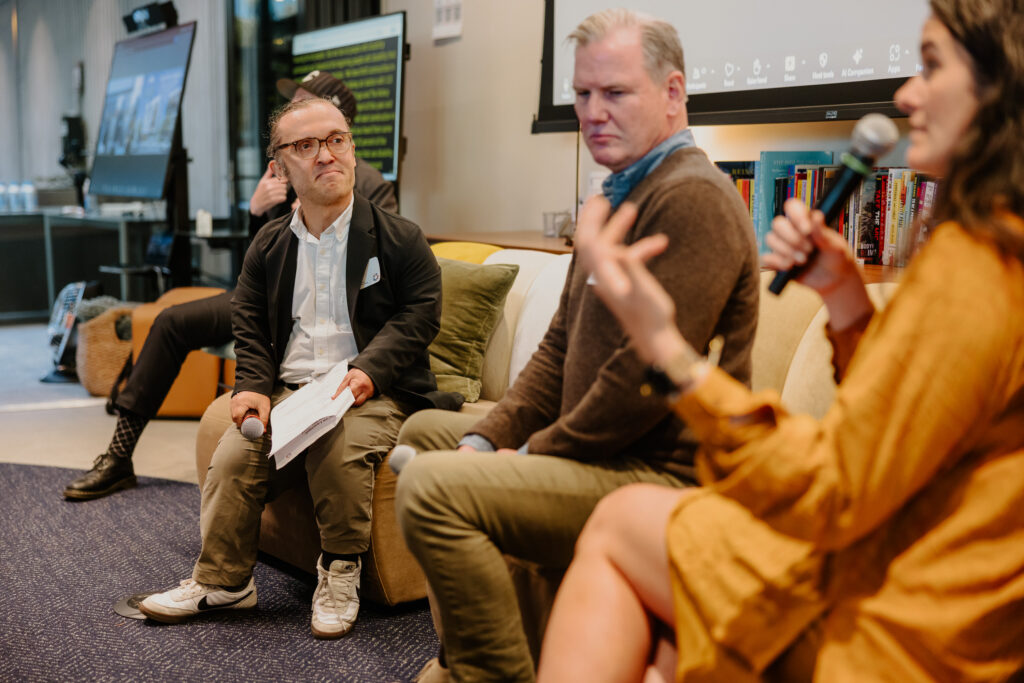 Three people on a couch speaking on a panel.