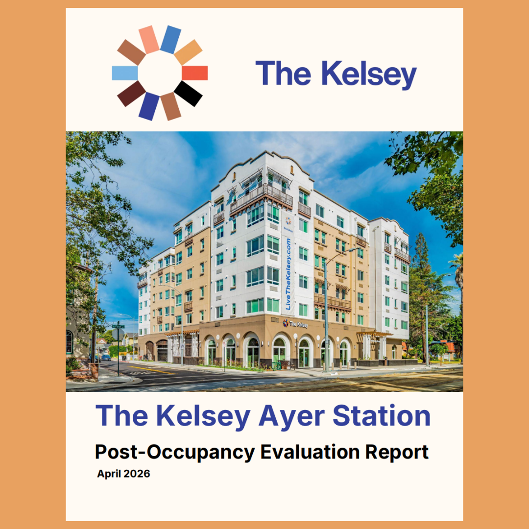 The cover page of the report: Centered at the top of the page is an image of The Kelsey’s wheel logo with the words “The Kelsey” to the right. Below that is a bright, colorful image of The Kelsey Ayer Station on a sunny day. The six-story building is white and tan with arches around the doors and windows on the bottom floor. Below the image are the words “The Kelsey Ayer Station Post-Occupancy Evaluation Report April 2026.”