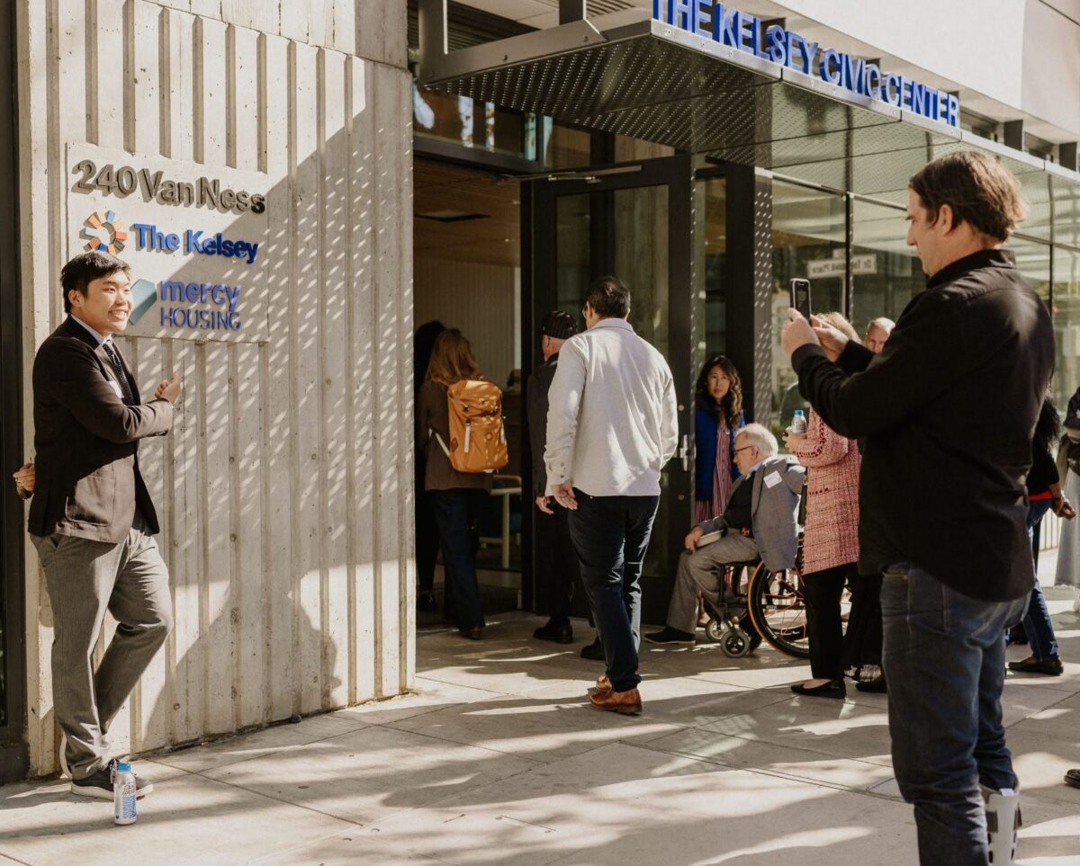 Attendees of the 2025 Disability-Forward Housing Futures Summit are pictured entering The Kelsey Civic Center to attend the event. The attendees are people with and without disabilities of different races and genders.