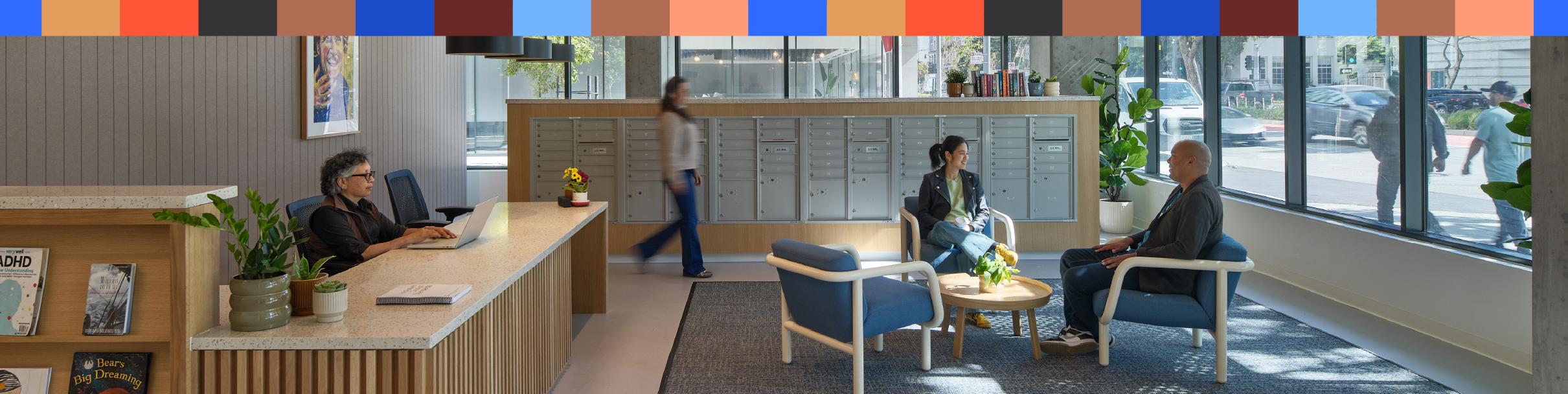Image of people sitting and walking through the lobby of an apartment building.