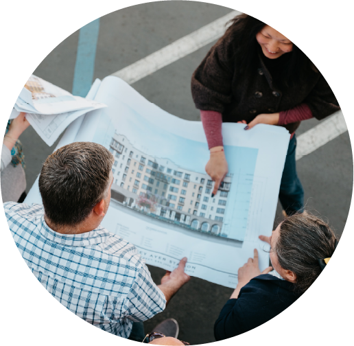 Image of a group of people looking at the drawing of an apartment building.